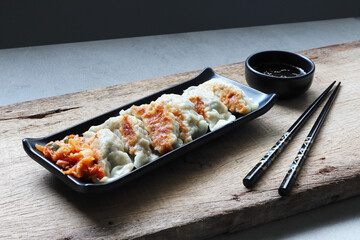 gyoza dumplings display in the black plate on the wooden table