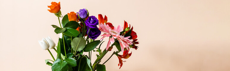 floral composition with bouquet of colorful flowers on beige background, panoramic crop