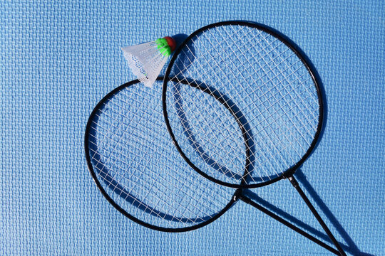 rackets and shuttlecock for playing badminton on a blue background, outdoor sports games