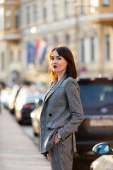 Woman in gray pantsuit walks on promenade