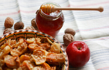Baked apples in a plate with honey and walnuts on the table