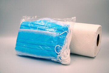 Pack of surgical face mask in plastic with tissue roll over white background
