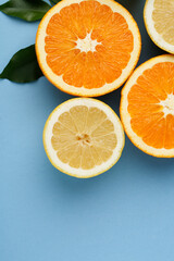 Oranges and lemon with orange juice on blue background
