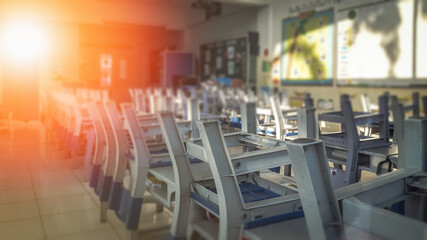 School classroom in blur background without young student; Blurry view of elementary class room no kid or teacher with chairs and tables in campus.