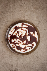 Jelly dessert with chocolate glaze on a cement background