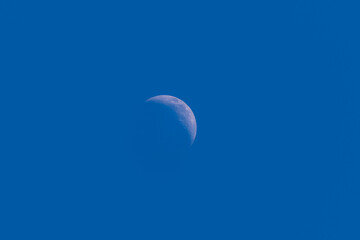 Mid Afternoon Quarter Moon Against Blue Sky