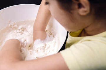 child mixing flour in bowl to make homemade bread