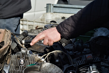 male hand pointing car part