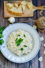 Italian creamy  cheese risotto with parmesan cheese and fresh basil on rustic background