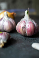Garlic, onions and beans on a dark background. Still life with onions of garlic and onions. Top view with place for text.