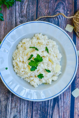 Italian creamy  cheese risotto with parmesan cheese and fresh basil on rustic background