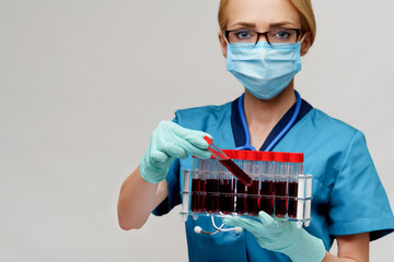 medical doctor nurse woman wearing protective mask and gloves - holding rack with virus blood tests