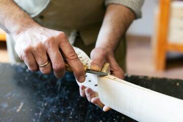 Luthier working on cello making in his workshop