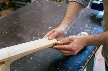 Luthier working on cello making in his workshop