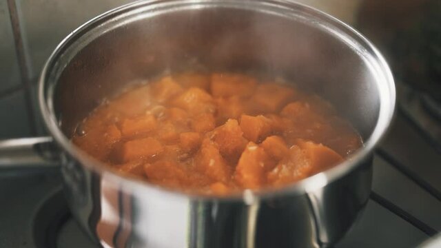Cooking pumpkin in a stainless steel saucepan slow motion