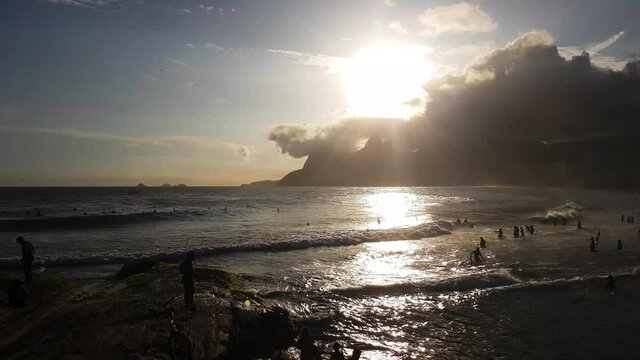 Evening Sun Over Ipanema Beach, Rio De Janeiro, Brazil. Ocean Waves and Silhouettes of People