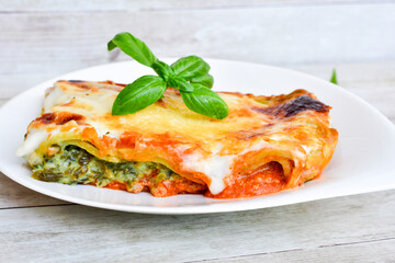   Delicious Home made Lasagna  with minced meat,tomato sauce and spinach  on a wooden rustic  background.Home made italian meal