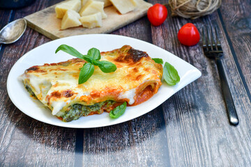   Delicious Home made Lasagna  with minced meat,tomato sauce and spinach  on a wooden rustic  background.Home made italian meal