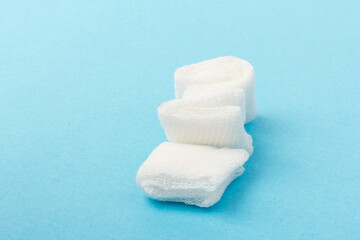 White gauze pads on  blue background. Materials for dental surgery. Close up