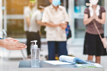 Fototapeta premium Clear alcohol gel bottles for hand cleaning to prevent the spreading of the corona virus (Covid-19). Place the entrance service with register book for customers before buying in the supermarket.