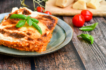   Delicious Home made Lasagna bolognese  with minced meat,tomato sauce and spinach  on a wooden rustic  background.Home made italian meal