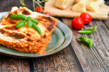   Delicious Home made Lasagna bolognese  with minced meat,tomato sauce and spinach  on a wooden rustic  background.Home made italian meal