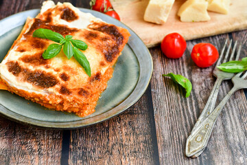   Delicious Home made Lasagna  with minced meat,tomato sauce and spinach  on a wooden rustic  background.Home made italian meal