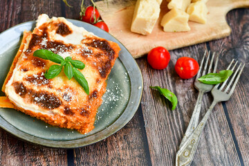   Delicious Home made Lasagna  with minced meat,tomato sauce and spinach  on a wooden rustic  background.Home made italian meal