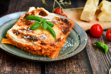   Delicious Home made Lasagna  with minced meat,tomato sauce and spinach  on a wooden rustic  background.Home made italian meal