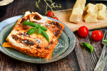   Delicious Home made Lasagna  with minced meat,tomato sauce and spinach  on a wooden rustic  background.Home made italian meal