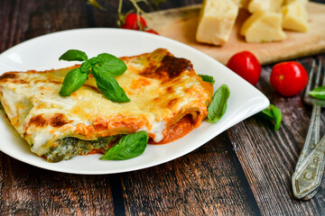   Delicious Home made Lasagna  with minced meat,tomato sauce and spinach  on a wooden rustic  background.Home made italian meal