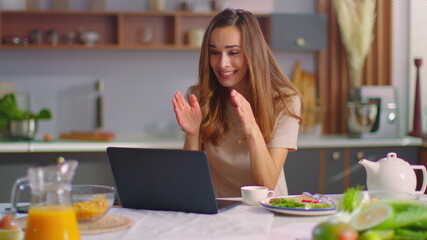 Woman talking with friend online on laptop. Lady gesturing on web camera at home