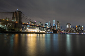 Fototapeta na wymiar New York City skyline behind the Brooklyn Bridge at night. 