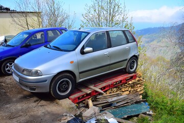 Obraz na płótnie Canvas A car parked on a stack of boards. Madeira, Portugal.