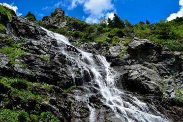Fototapeta na wymiar Capra Waterfall next to Transfagarasan alpine mountain road in southern section of Carpathian Mountains in Romania