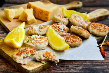 Home made italian  chicken  meatballs  with parmesan cheese, chily peppers and fresh  lemon on  rustic background. Diet food.