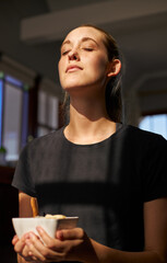 Young female holding healthy breakfast bowl