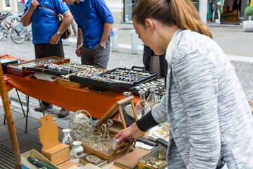Female customer checking items sold at flee market.