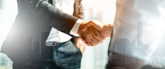 Fotobehang Businessman handshake for teamwork of business merger and acquisition,successful negotiate,hand shake,two businessman shake hand with partner to celebration partnership and business deal concept © Yingyaipumi