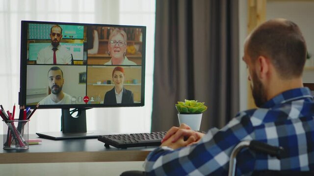 Invalid freelancer in wheelchair during a video call working from home. Handicapped invalid paralysed freelancer, immobilized entrepreneur working from home, ilness and disability