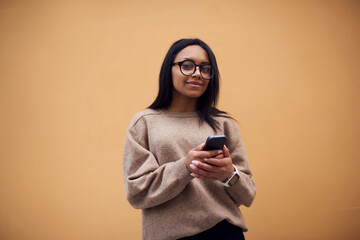 Beautiful hipster girl with cellular phone in hands