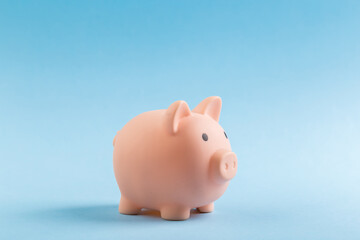 pink piggy bank on blue background.  The concept of saving money or savings, investment