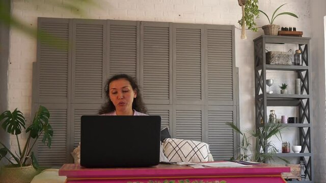 A business woman talks to colleagues via video link. Online chat. 