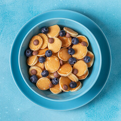 Trendy breakfast with mini pancakes, blueberries and chocolate chips.