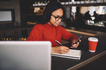 Portrait of afro american student sitting in coffee shop on break looking at camera 