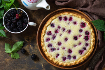 Homemade blackberry pie. Sweet pie with blackberry on rustic wooden table. Top view flat lay background. Copy space.