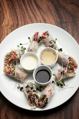 asian fresh vegetable vegan spring rolls with sauces in vietnam