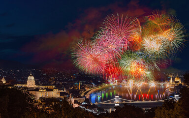 St Sephen memorial day in Budapest Hungary. Celebration fireworks over Danube river. Famous historical Buda castle on the left side  Chain bridge on bottom and Hungarian parliament on  right.