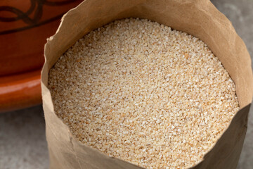 Paper bag with barley grits close up
