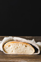 Fresh baked white bread slice slice on a dark background. Front view copy space.